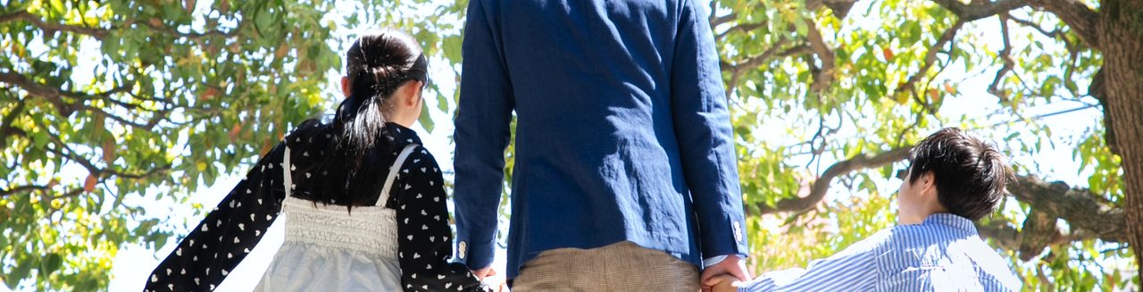 子どもと手をつないで歩く、おぎの広光の後ろ姿
